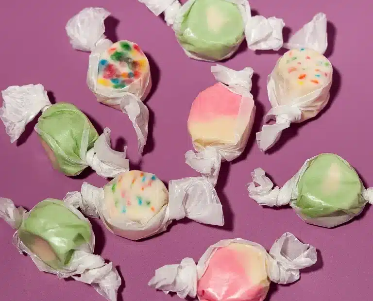 Hometown Hero Live Rosin Taffy candies in assorted pastel colors, individually wrapped and displayed on a purple background.