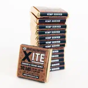 Stacked Xite Cookies and Cream Delta 9 Chocolate Minis wrapped in gold and brown packaging labeled hemp-derived.